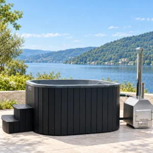Quadro 202 Acryl-Hot-Tub mit schwarzer WPC-Verkleidung, Treppe und externem Holzofen auf einer Terrasse mit Seeblick